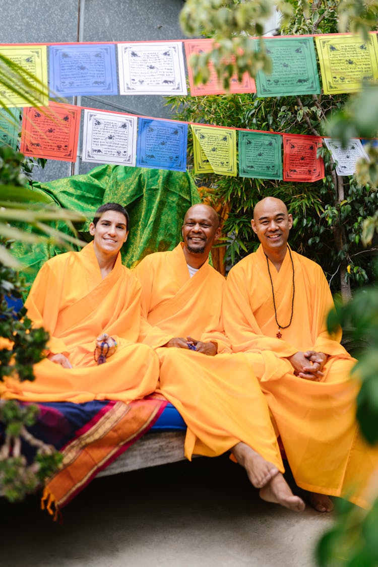 Men In Yellow Robes Holding Sitting In The Garden