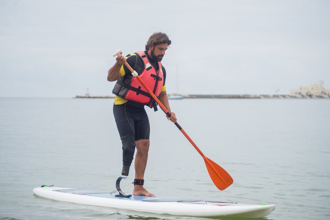A Man with Prosthetics Paddle Boarding