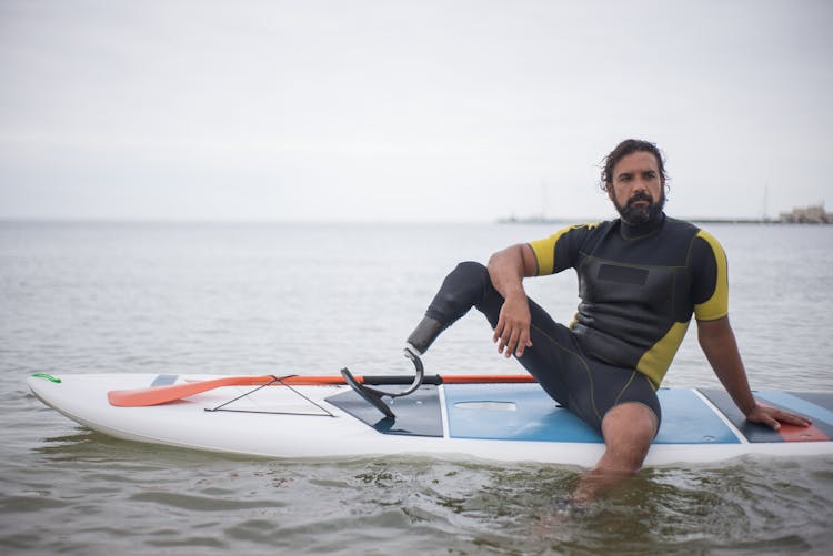 A Man Sitting On A Sup Board