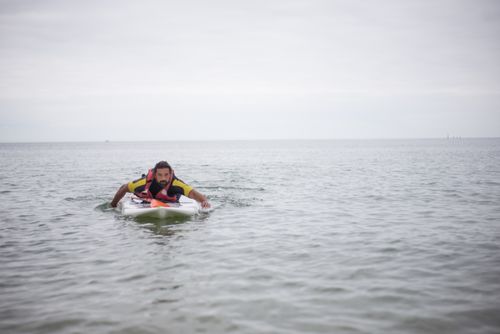 Free Man with disability paddleboarding on calm ocean waters in Portugal. Stock Photo