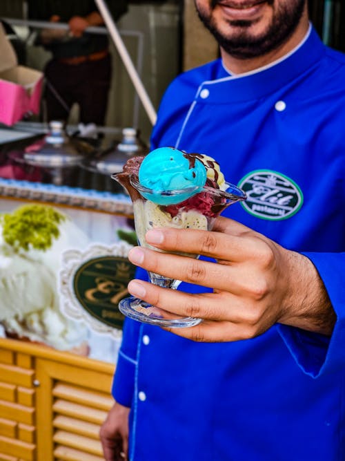 Free A Man in Blue Polo Shirt Holding Ice Cream in Glass Cup Stock Photo