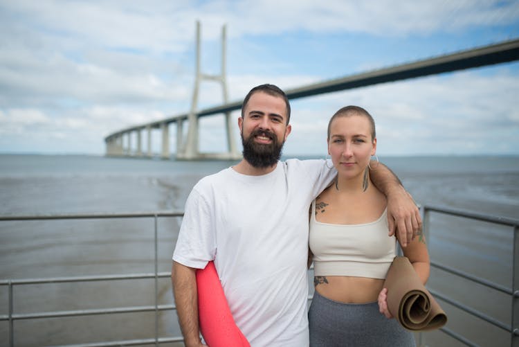 A Man Standing Beside A Woman With His Arm Around Her Shoulder