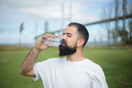 Man in White Shirt Drinking a Bottled Water