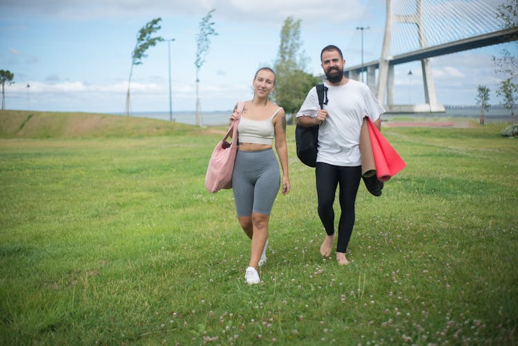 A Couple Walking On A Field