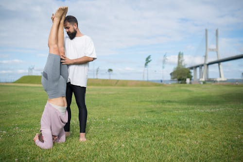 Man and Woman Working Out on the Grass Field