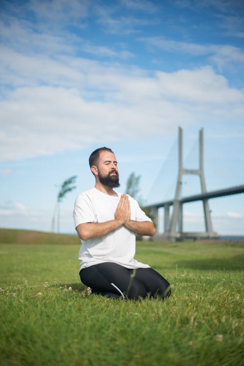 A Man Meditating on the Grass Field