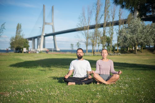 Free Man and Woman Meditating at the Park Stock Photo
