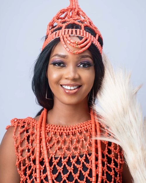Free Portrait of a smiling woman in traditional African attire with a coral crown and beads. Stock Photo