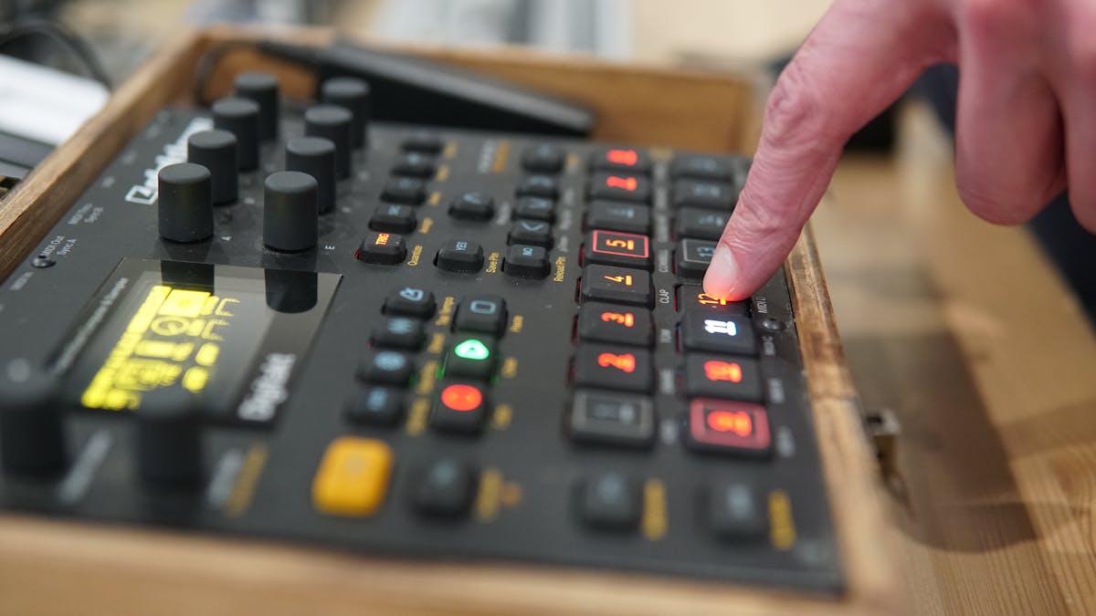 Dito che preme un pulsante su un pannello di controllo nero