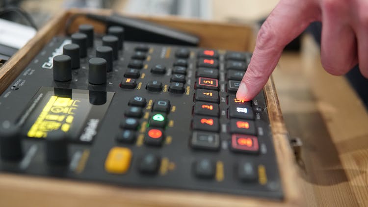 A Finger Pressing On A Button Of A Black Control Panel