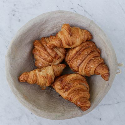 Golden croissants in a linen basket, photo by Emmanuel Zua on Pexels