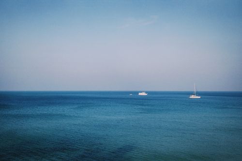 Free Tranquil blue sea with boats under a clear sky in Tambon Ko Chang, Thailand. Stock Photo