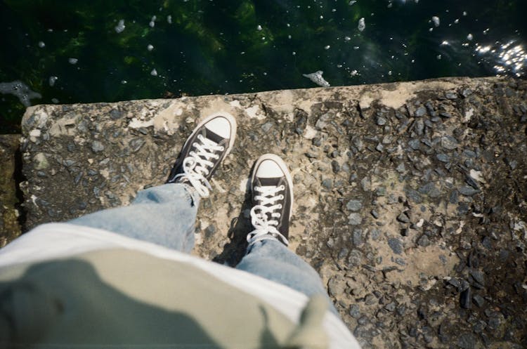 A Person Standing On The Concrete Edge