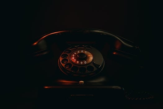Classic vintage rotary phone capturing nostalgia with dim lighting and sepia tones.