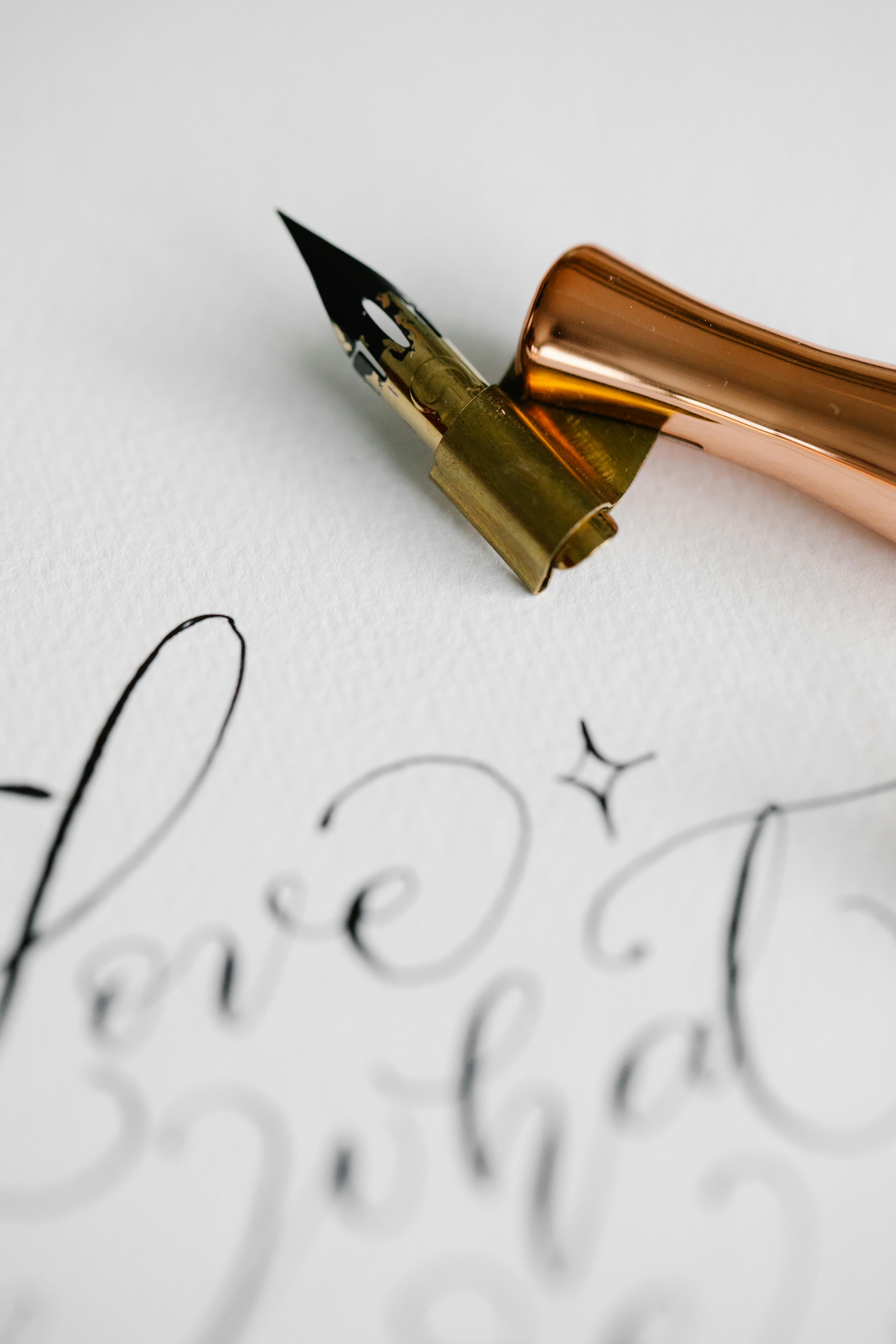 close up of an ink pen and calligraphic writing