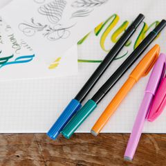 Colourful brush pens on a sheet of hand lettering