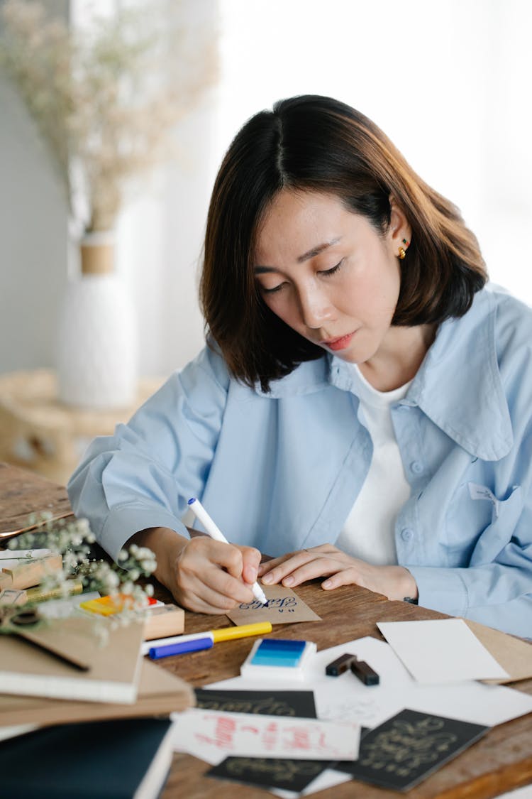 A Woman Writing On A Card