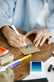 Elegant calligraphy in progress, showcasing precise handwriting by a skilled artist.