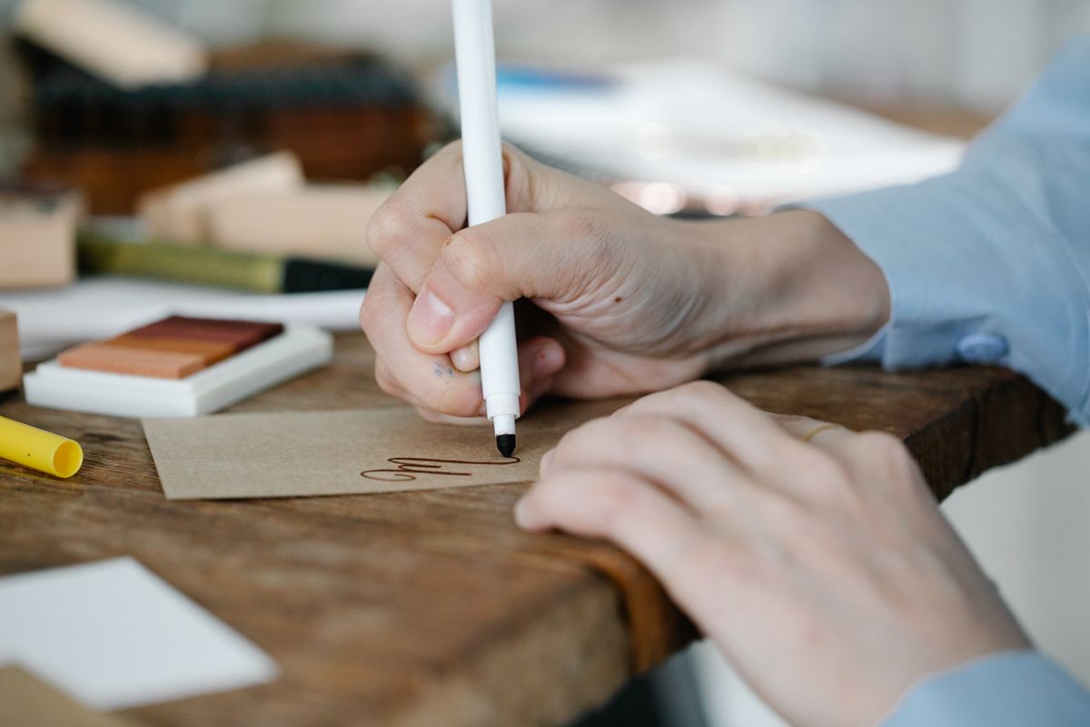 Eine persönliche Zeile wird von Hand auf eine Karte geschrieben – der Text macht das Geschenk besonders