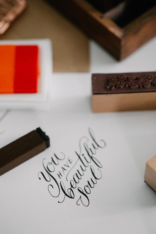 Free Close-up of elegant calligraphy 'You have beautiful soul' with ink stamps and paper. Stock Photo