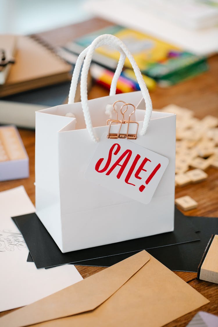 Close-up Of A White Paper Bag With Sale Card