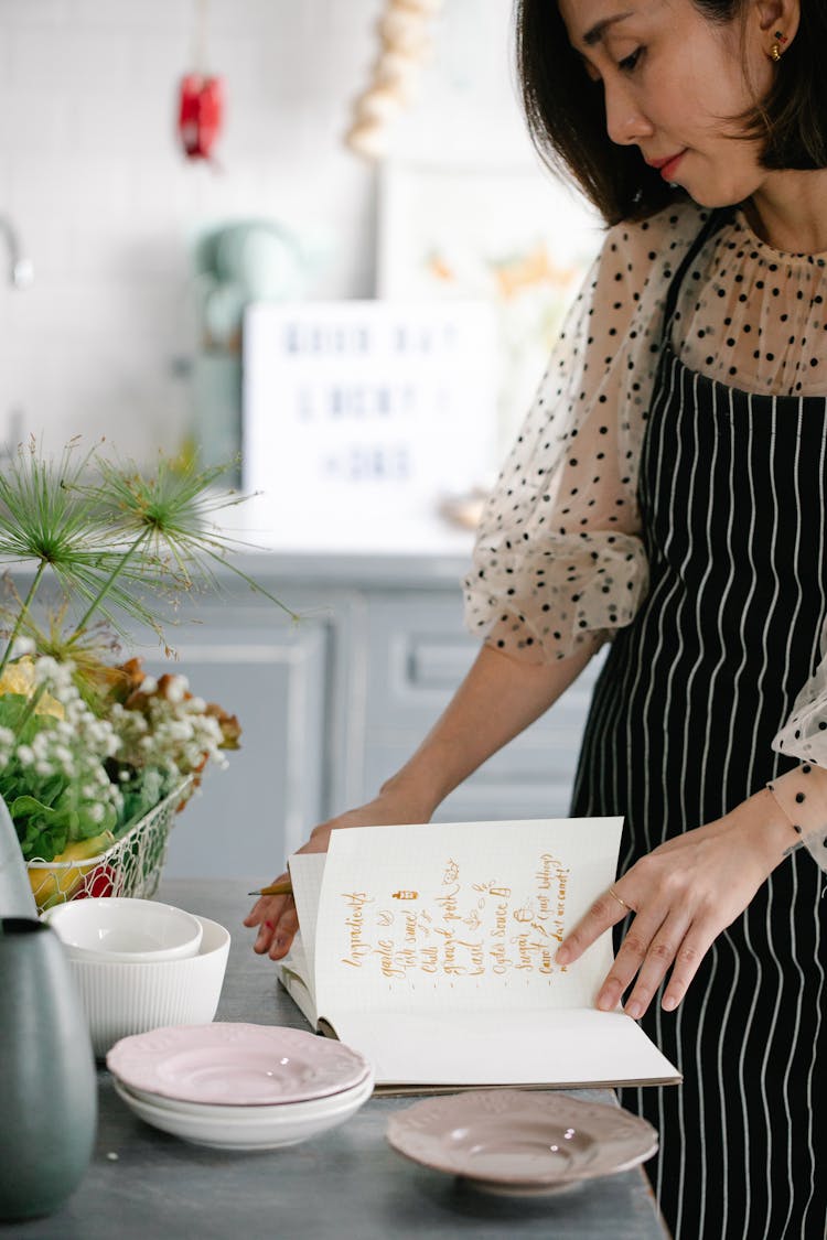 Side View Of A Woman Reading A Cookbook