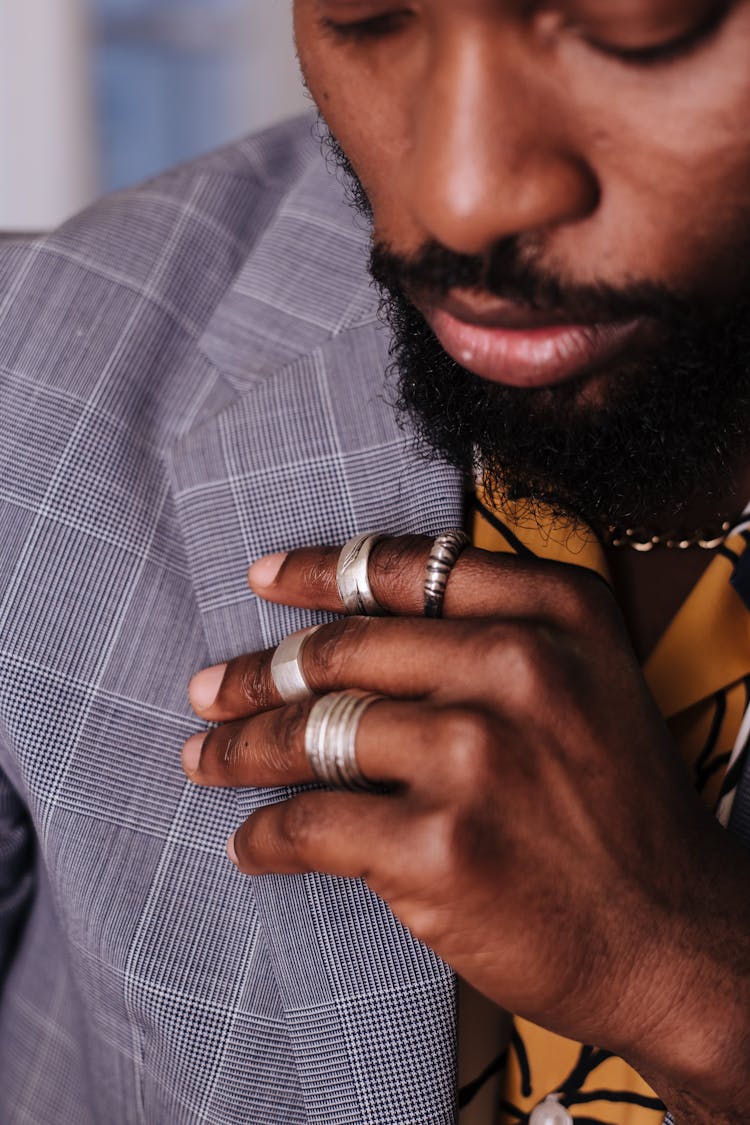 A Man Touching The Lapel Of His Gray And White Pinstripe Jacket