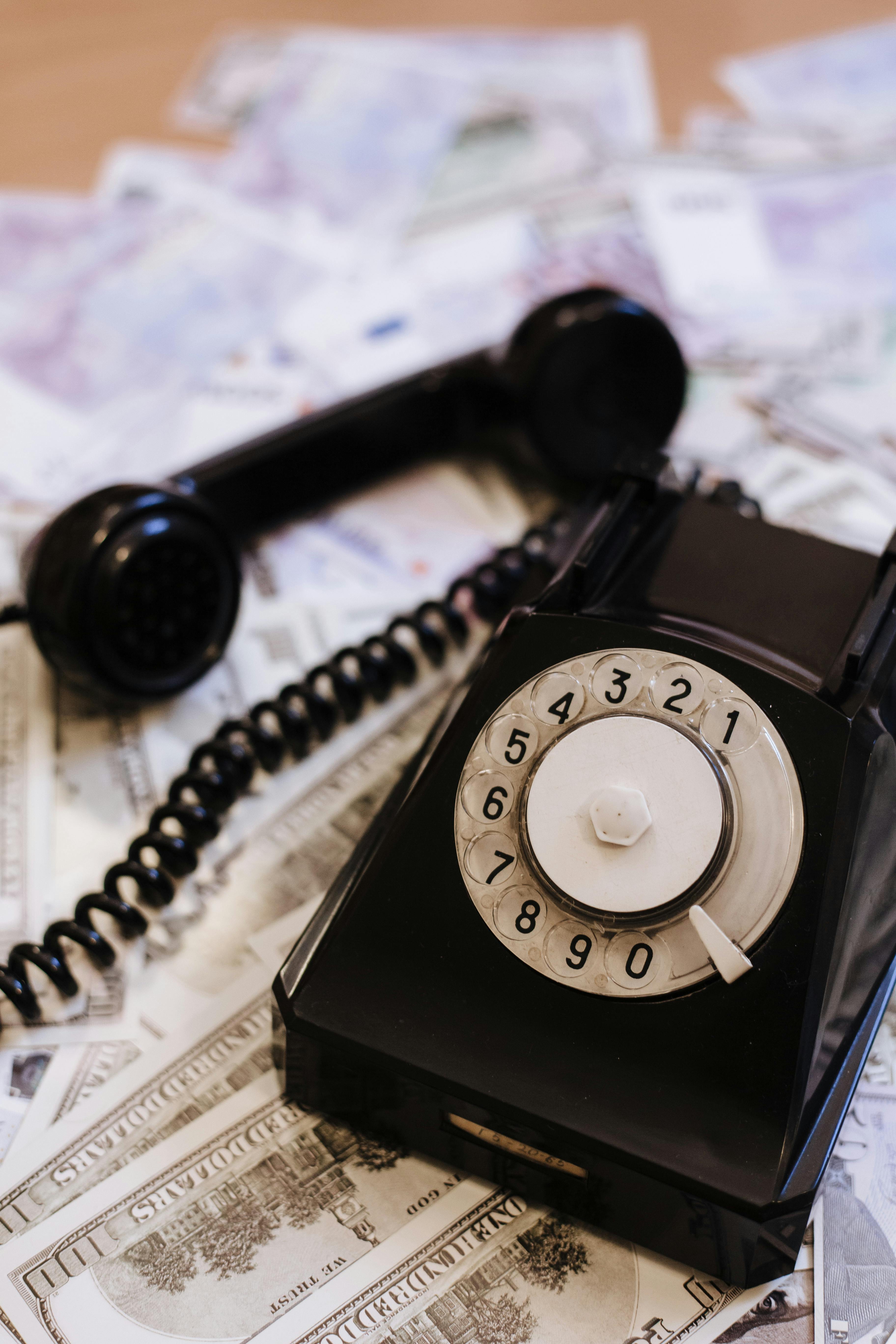 a telephone on top of dollar bills