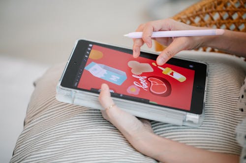 Person Holding a Tablet and a Pen