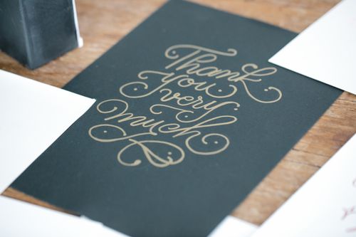 Free Close-up of a stylish thank you card with handwritten script on a wooden table. Stock Photo