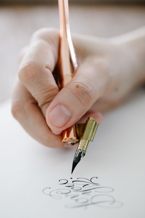 Forehead Writing Close-up of Person Writing Calligraphic Letters · Free Stock Photo