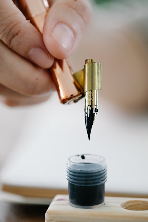 Free A Person Writing Using a Fountain Pen Stock Photo