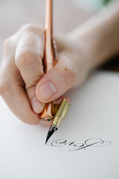 Free Hand of a Person Using a Calligraphy Pen Stock Photo
