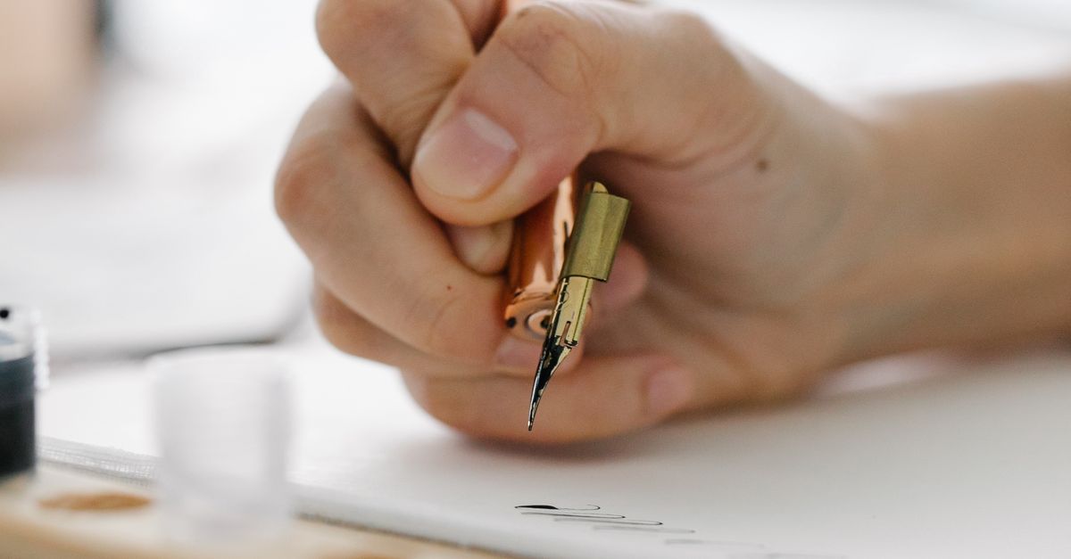 Close-up of Person Writing with an Ink Pen · Free Stock Photo