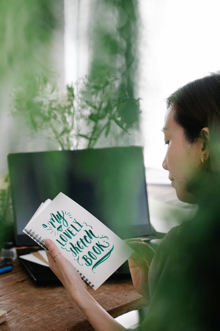 A Woman Holding A Sketchbook