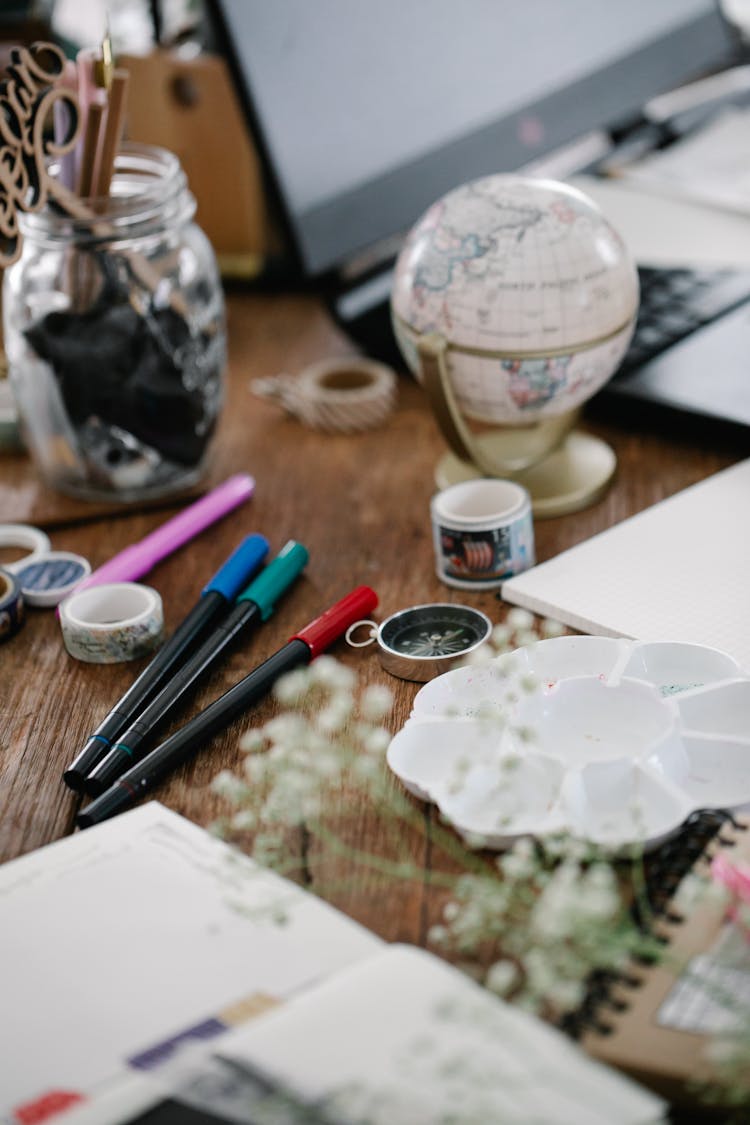 Pens And Mini Globe On Desk