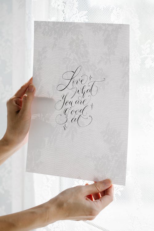 Free Person Holding White Printer Paper With Cursive Handwriting Stock Photo