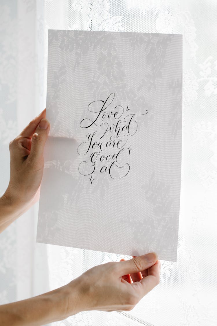 Person Holding White Printer Paper With Cursive Handwriting
