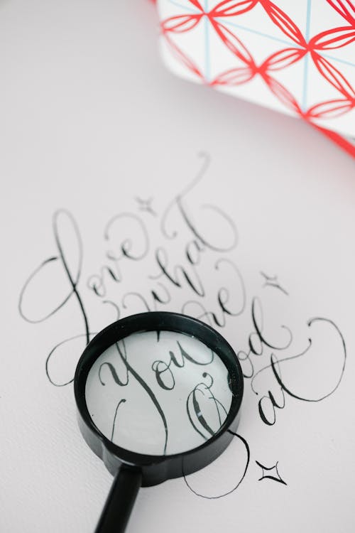 A Magnifier on a Paper Sheet with Calligraphic Letters 
