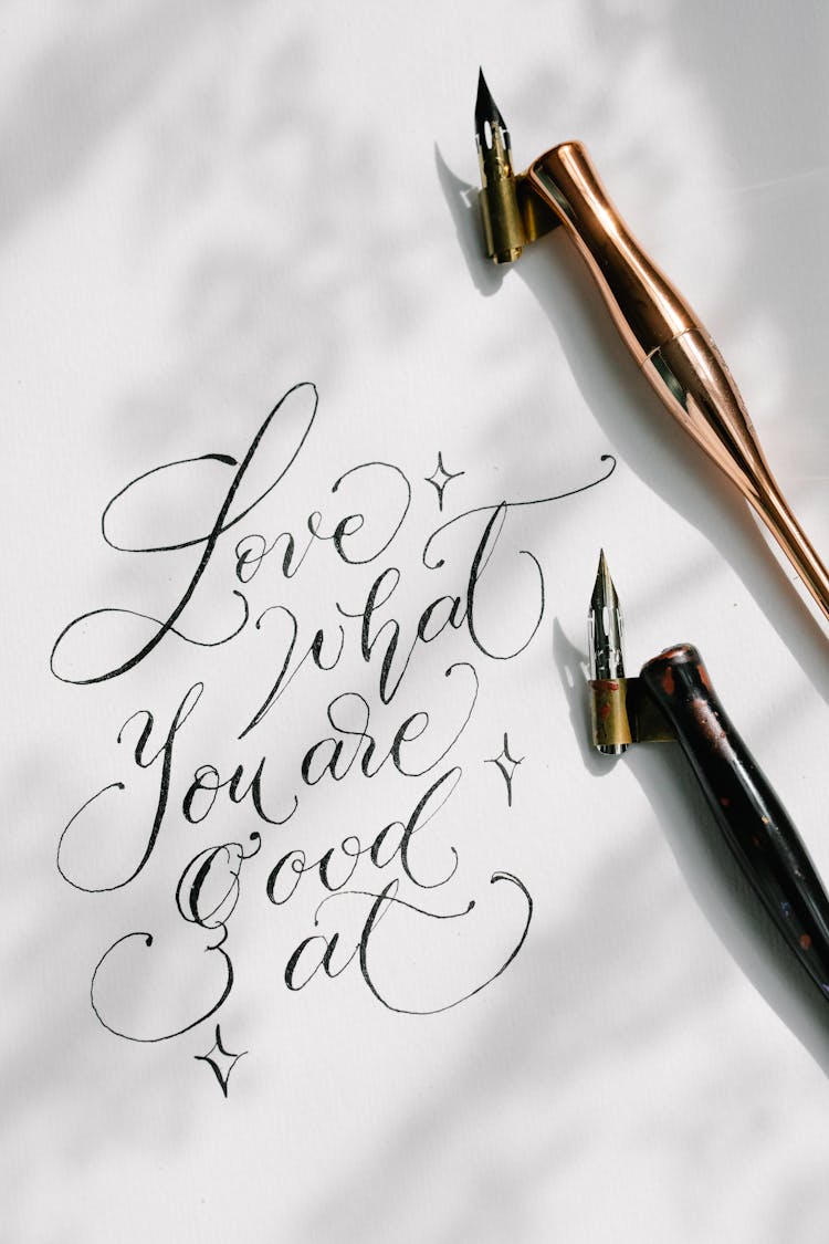 Close-up Of A Cursive Writing On A White Paper