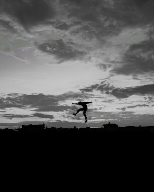Monochrome Photo of Person Doing a Jump Shot