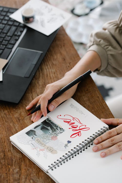 Free Person Holding White Paper on a Notebook Stock Photo