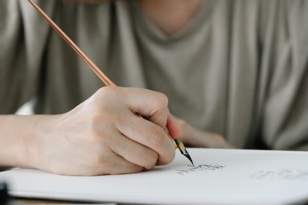 Close-up of a calligraphy pen mid-stroke — photo by Katya Wolf on Pexels