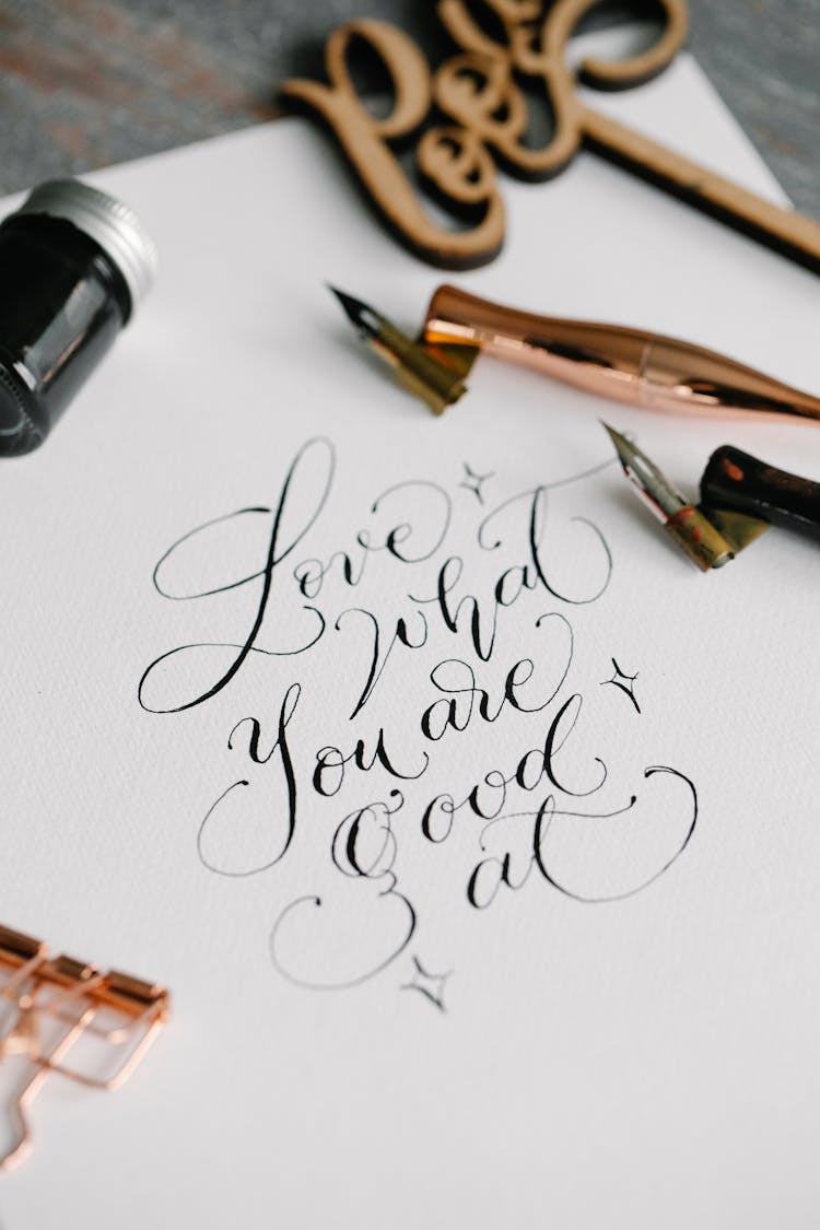 Cursive Lettering On The White Paper