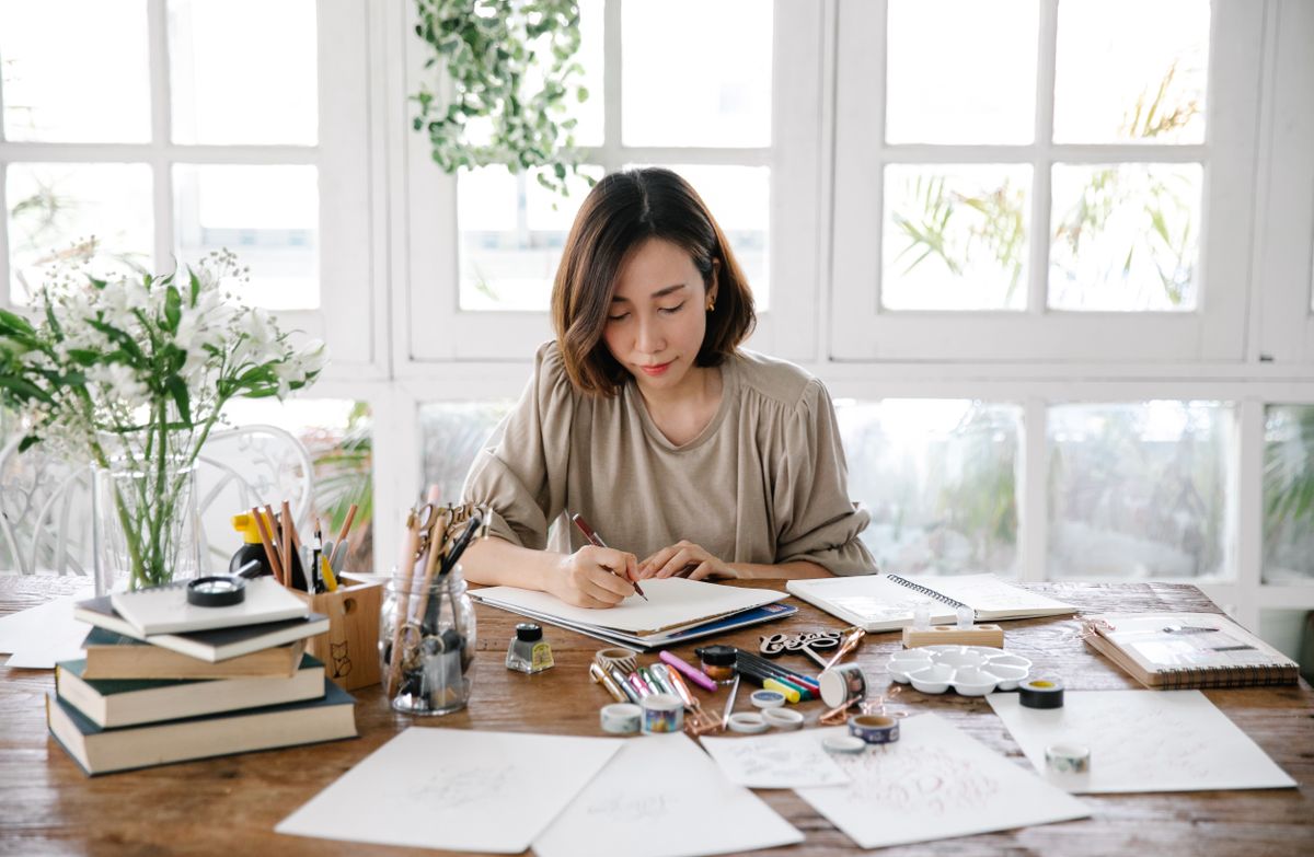 Calligrapher lettering at a sunlit studio desk — photo by Katya Wolf on Pexels