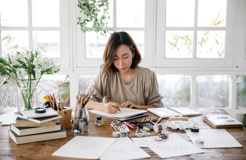 Maker working at a craft table with tools and notes, photo by Katya Wolf on Pexels