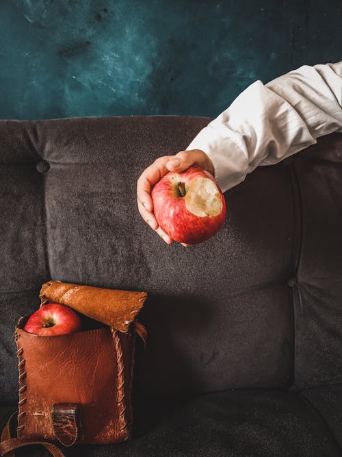 Person Holding a Bitten Red Apple