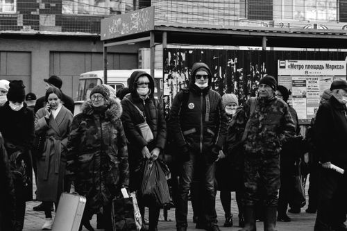 Free Crowd of people in winter clothing and masks on a city street. Stock Photo
