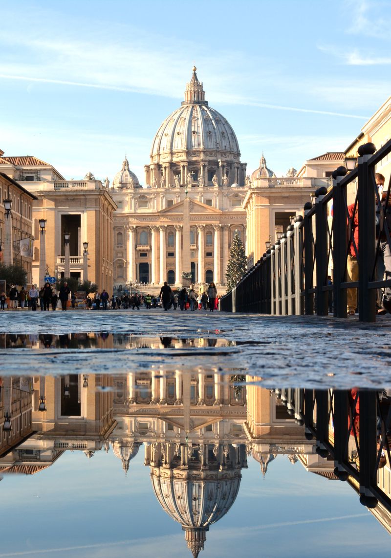 St. Peter's Basilica dome reflecting in a puddle in Vatican City