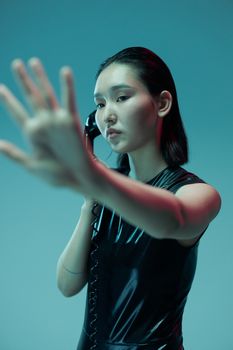 An artistic shot of a woman reaching forward, holding a retro phone against a futuristic background.